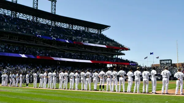 This photo shows the Rockies, wearing purple pinstripes, lined up at Coors Field on Opening Day. 