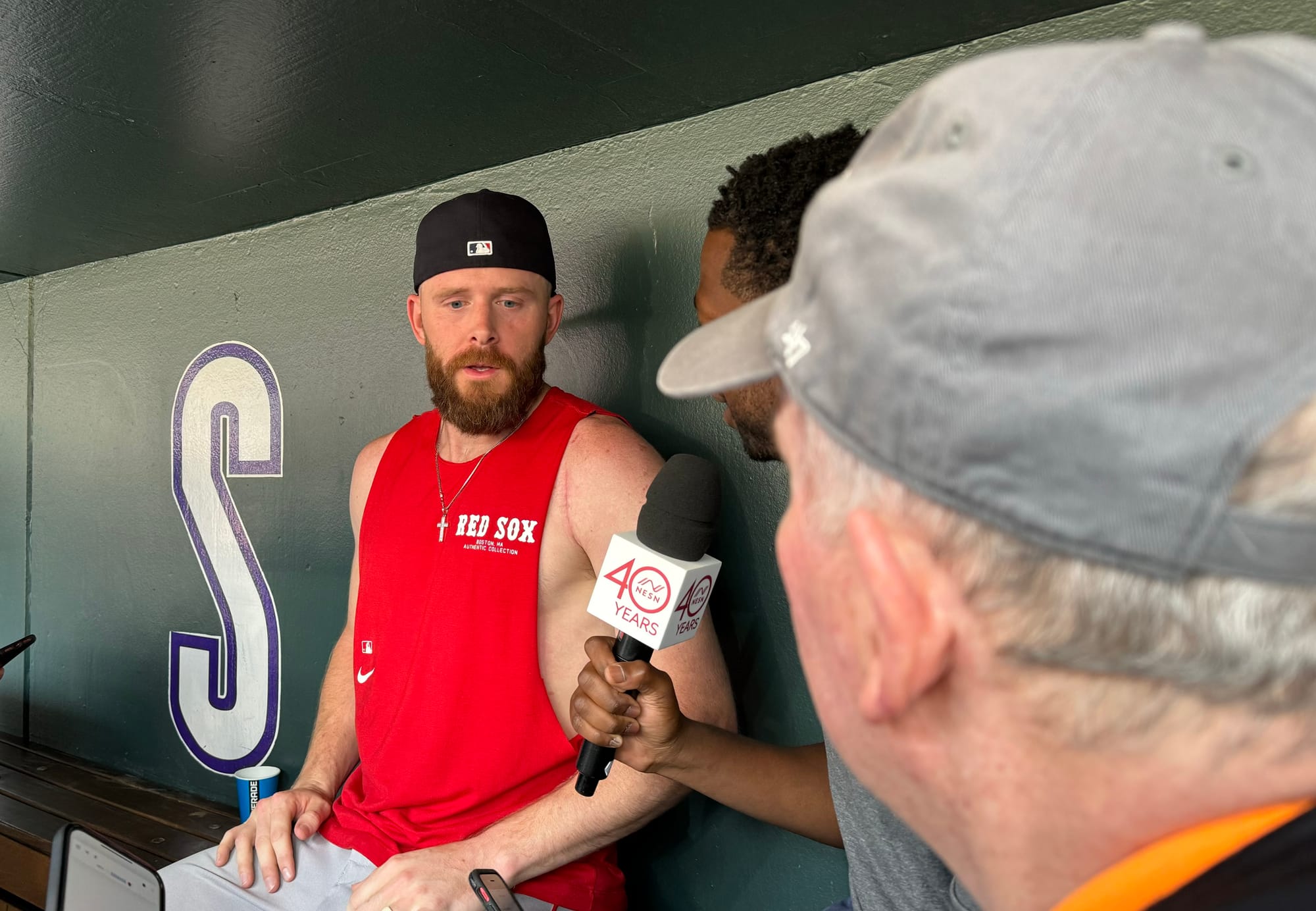 Story’s wearing a red Red Sox t-shirt with the sleeves cut off and a backwards baseball cap.