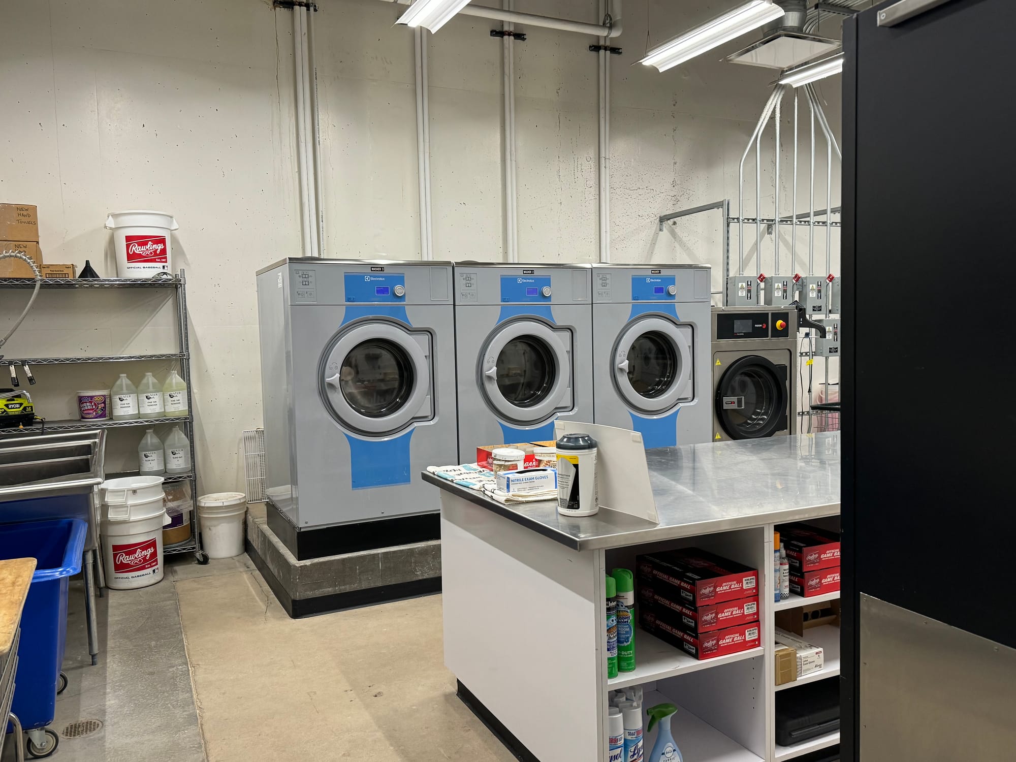 Three washing machines are visible along with other cleaning gear.